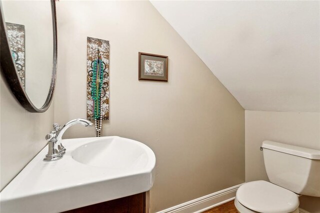 511 Beau Chene Dr, Mandeville, LA 70471 - half bath featuring lofted ceiling, toilet, vanity, and baseboards