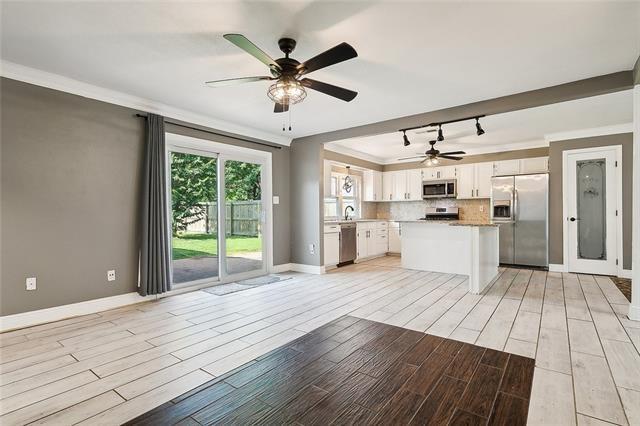 312 Raleigh Dr, Slidell, LA 70460 - kitchen with appliances with stainless steel finishes, ceiling fan, light wood-style flooring, open floor plan, and light countertops