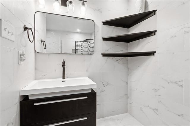 312 Raleigh Dr, Slidell, LA 70460 - bathroom with vanity, marble finish flooring, and a shower