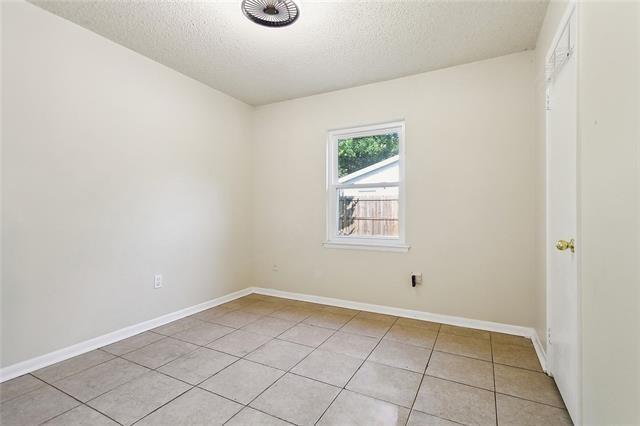312 Raleigh Dr, Slidell, LA 70460 - empty room with light tile patterned floors, a textured ceiling, and baseboards