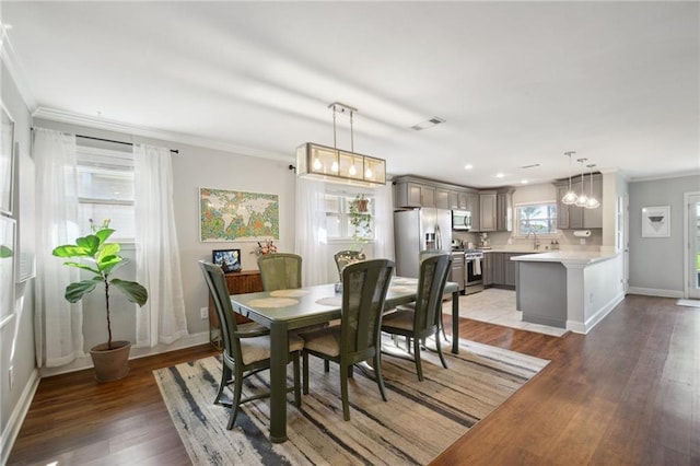 4709 Kawanee Ave, Metairie, LA 70006 - dining space featuring crown molding, baseboards, light wood-style floors, a chandelier, and recessed lighting