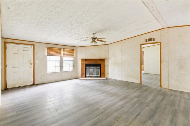 16940 Gunboat Landing Rd, Livingston, LA 70449 - unfurnished living room with a ceiling fan, wood finished floors, vaulted ceiling, a glass covered fireplace, and crown molding