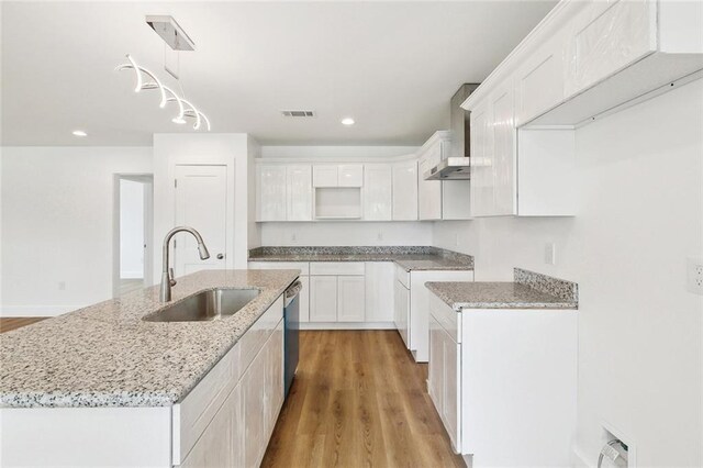 2305 Weyer St, Gretna, LA 70053 - kitchen with a sink, stainless steel dishwasher, light stone counters, a kitchen island with sink, and white cabinetry