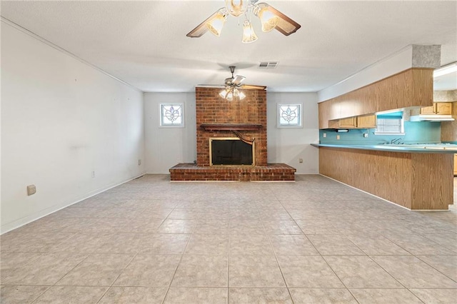 1816 Giuffrias Ave, Metairie, LA 70001 - unfurnished living room featuring ceiling fan, healthy amount of natural light, light tile patterned floors, and a fireplace
