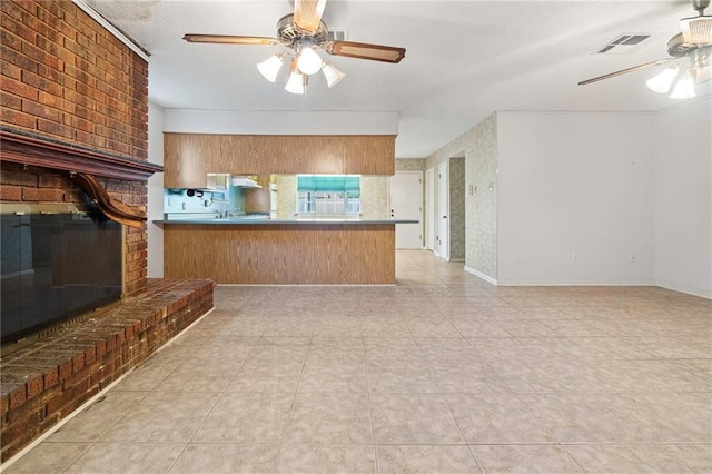 1816 Giuffrias Ave, Metairie, LA 70001 - kitchen featuring ceiling fan, open floor plan, tile patterned flooring, a peninsula, and brown cabinetry