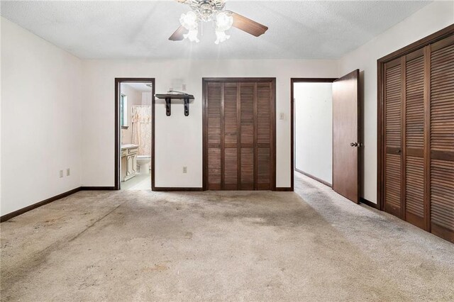 1816 Giuffrias Ave, Metairie, LA 70001 - unfurnished bedroom with two closets, light carpet, baseboards, ensuite bath, and ceiling fan