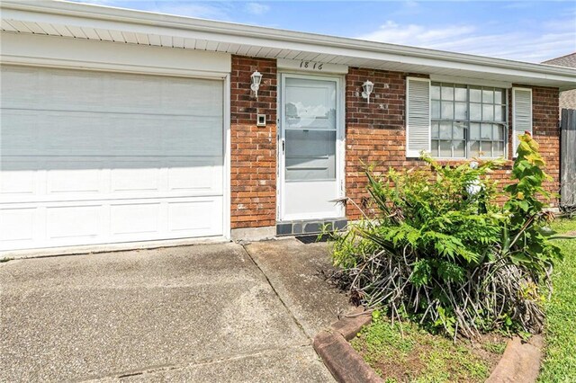 1816 Giuffrias Ave, Metairie, LA 70001 - view of front facade with brick siding, an attached garage, and driveway