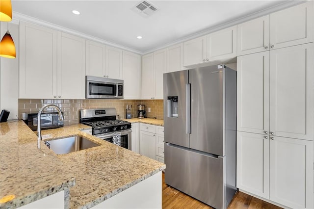 220 Decatur St Unit 302, New Orleans, LA 70130 - kitchen featuring stainless steel appliances, a sink, white cabinets, light stone counters, and recessed lighting