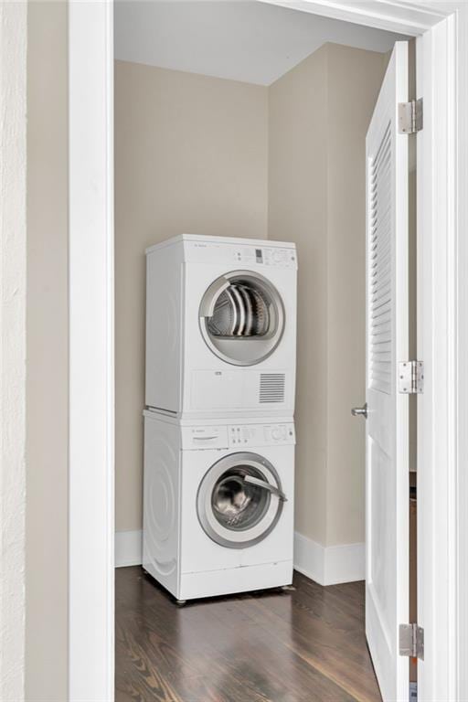 220 Decatur St Unit 304, New Orleans, LA 70130 - laundry area with stacked washer / drying machine, baseboards, and dark wood-style floors