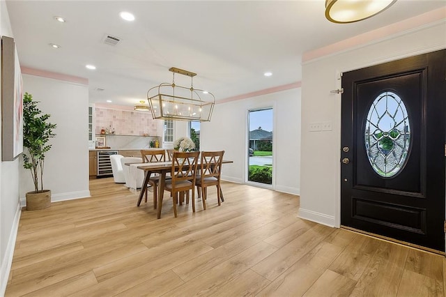 4721 Chastant St, Metairie, LA 70006 - dining area with light wood finished floors, baseboards, crown molding, recessed lighting, and wine cooler