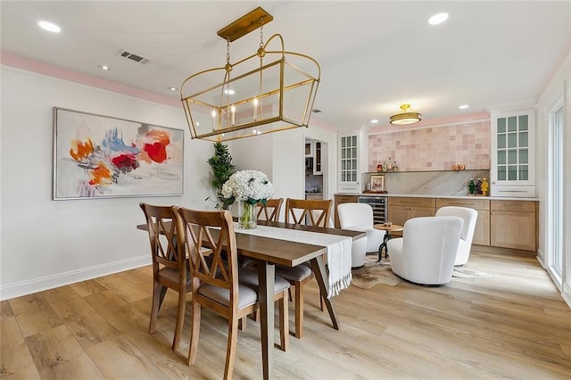 4721 Chastant St, Metairie, LA 70006 - dining room featuring recessed lighting, light wood-style floors, wine cooler, crown molding, and baseboards