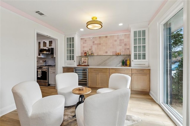 4721 Chastant St, Metairie, LA 70006 - dining space with beverage cooler, a bar, healthy amount of natural light, recessed lighting, and light wood-style flooring