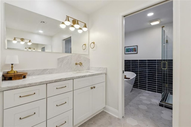 4721 Chastant St, Metairie, LA 70006 - full bath featuring tile patterned flooring, vanity, a shower stall, a freestanding bath, and tile walls
