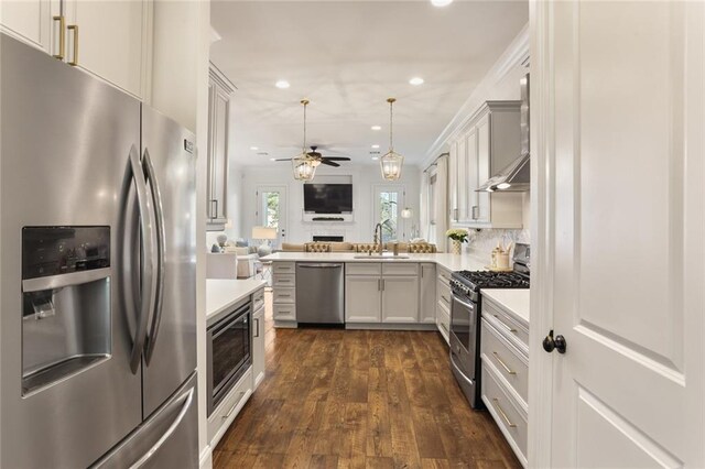 247 26th St, New Orleans, LA 70124 - kitchen with stainless steel appliances, a sink, open floor plan, light countertops, and dark wood finished floors