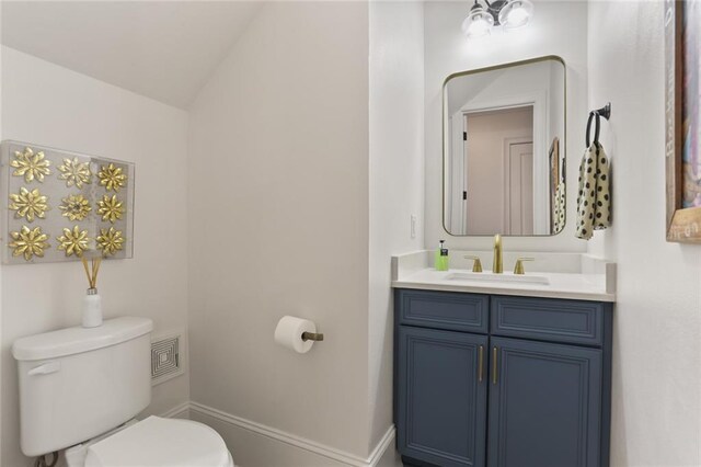247 26th St, New Orleans, LA 70124 - bathroom with toilet, vanity, baseboards, and lofted ceiling