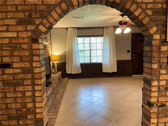 10311 Gatlin Rd, Hammond, LA 70403 - unfurnished living room with wainscoting, arched walkways, ceiling fan, and tile patterned floors
