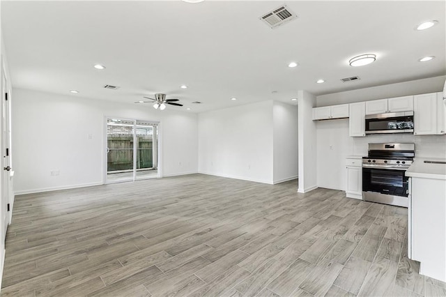 7504 Birch St, Violet, LA 70092 - kitchen with stainless steel appliances, a ceiling fan, white cabinetry, light countertops, and baseboards