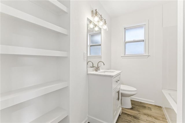 7504 Birch St, Violet, LA 70092 - bathroom with vanity, toilet, wood finished floors, and baseboards