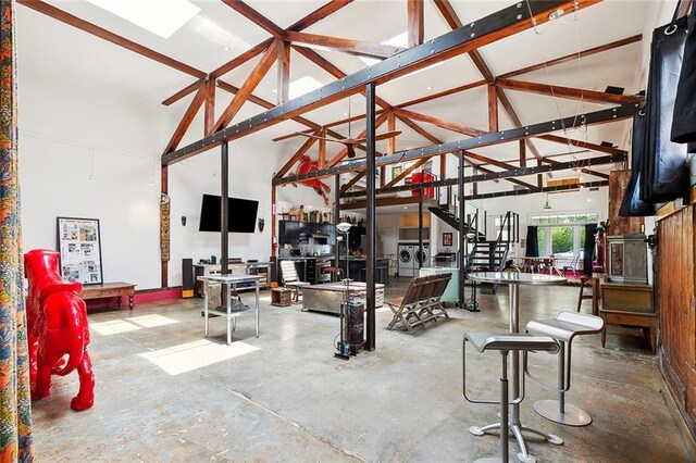 3300 Dumaine St, New Orleans, LA 70119 - living area with washing machine and clothes dryer, high vaulted ceiling, and concrete floors