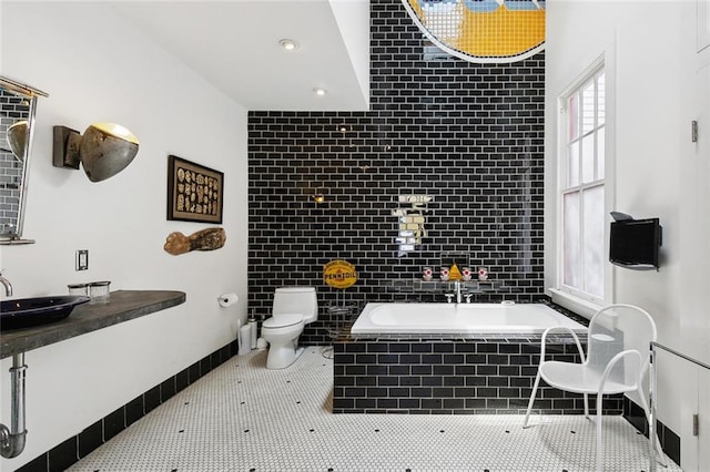 3300 Dumaine St, New Orleans, LA 70119 - full bathroom featuring toilet, a relaxing tiled tub, and a sink