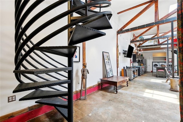 3300 Dumaine St, New Orleans, LA 70119 - stairway featuring washer and dryer, unfinished concrete floors, and a high ceiling