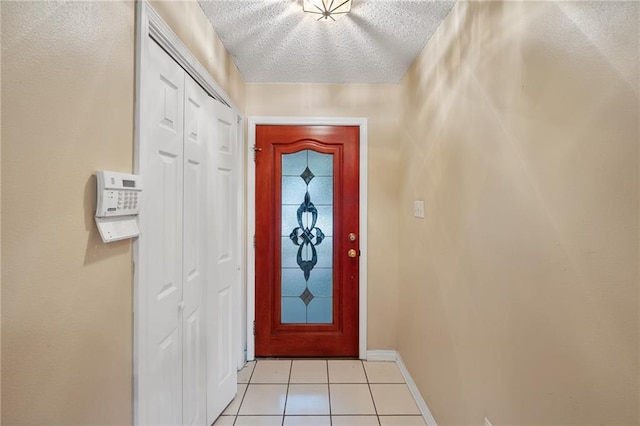 374 E Suncrest Loop, Slidell, LA 70458 - doorway to outside featuring baseboards, light tile patterned floors, and a textured ceiling