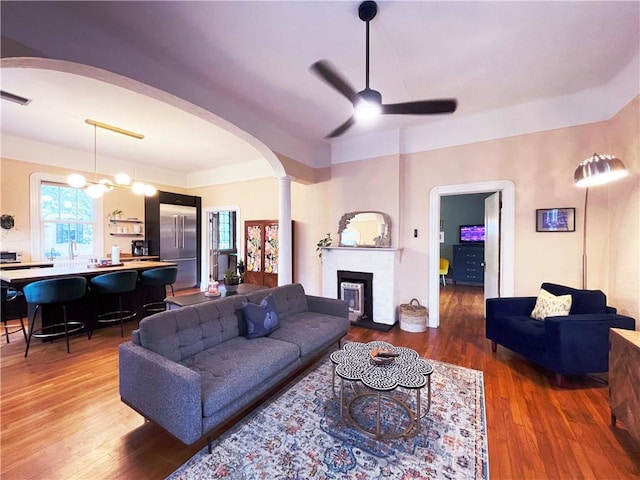 1500 Camp St, New Orleans, LA 70130 - living area featuring arched walkways, ceiling fan, wood finished floors, and a fireplace