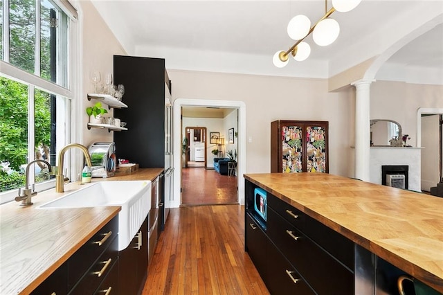 1500 Camp St, New Orleans, LA 70130 - kitchen featuring wooden counters, dark cabinetry, ornate columns, and arched walkways