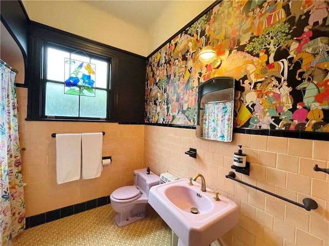 1500 Camp St, New Orleans, LA 70130 - full bathroom featuring toilet, wainscoting, a sink, tile walls, and tile patterned floors