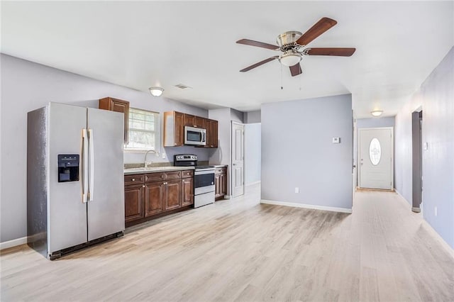1319 Granada Dr, New Orleans, LA 70122 - kitchen with appliances with stainless steel finishes, ceiling fan, light wood-type flooring, light countertops, and baseboards