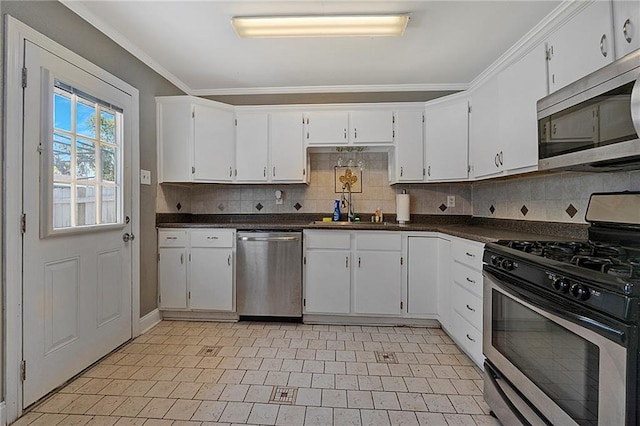 3620 Arizona Ave, Kenner, LA 70065 - kitchen with appliances with stainless steel finishes, a sink, tasteful backsplash, dark countertops, and ornamental molding