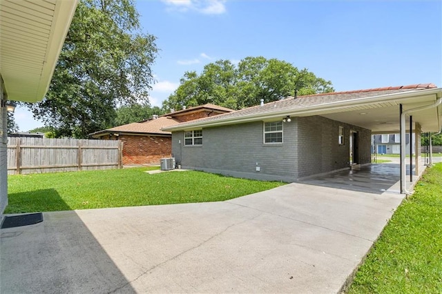 228 W Kenilworth-A St, New Orleans, LA 70124 - rear view of property featuring brick siding, concrete driveway, an attached carport, and central air condition unit
