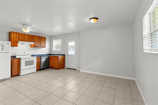 228 W Kenilworth-A St, New Orleans, LA 70124 - kitchen with white appliances, under cabinet range hood, a sink, brown cabinets, and baseboards
