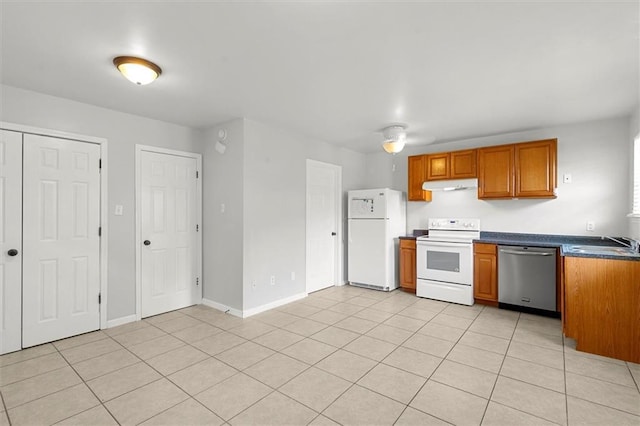 228 W Kenilworth-A St, New Orleans, LA 70124 - kitchen with white appliances, under cabinet range hood, brown cabinetry, a sink, and dark countertops