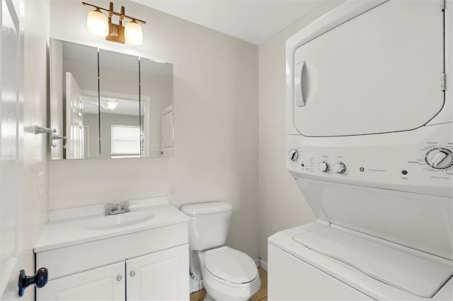 228 W Kenilworth-A St, New Orleans, LA 70124 - bathroom with stacked washer / drying machine, vanity, toilet, and baseboards