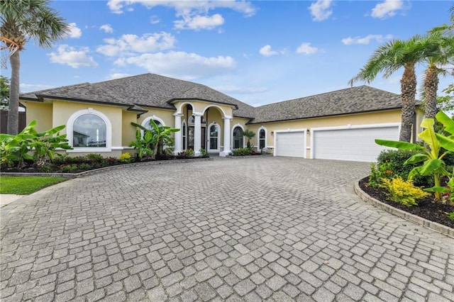 2097 S Lakeshore Blvd, Slidell, LA 70461 - french country style house with stucco siding, decorative driveway, and a garage