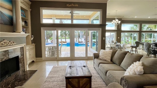 2097 S Lakeshore Blvd, Slidell, LA 70461 - living area with a fireplace, light tile patterned floors, baseboards, ornamental molding, and a chandelier