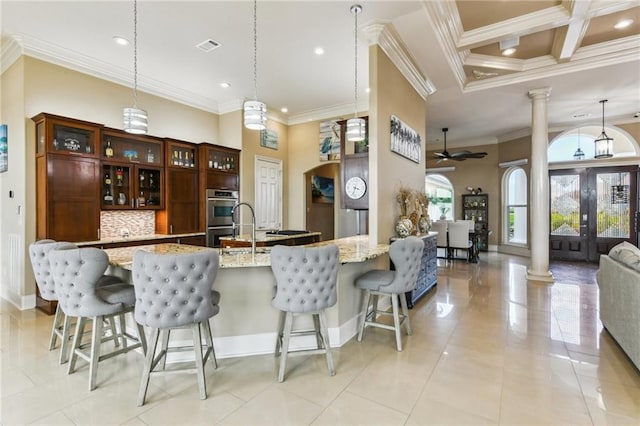 2097 S Lakeshore Blvd, Slidell, LA 70461 - kitchen featuring ornate columns, stainless steel double oven, arched walkways, a ceiling fan, and ornamental molding