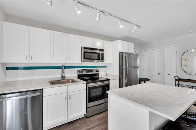 2833 St Charles Ave Unit 16, New Orleans, LA 70115 - kitchen with appliances with stainless steel finishes, a sink, white cabinets, a kitchen island, and a breakfast bar area