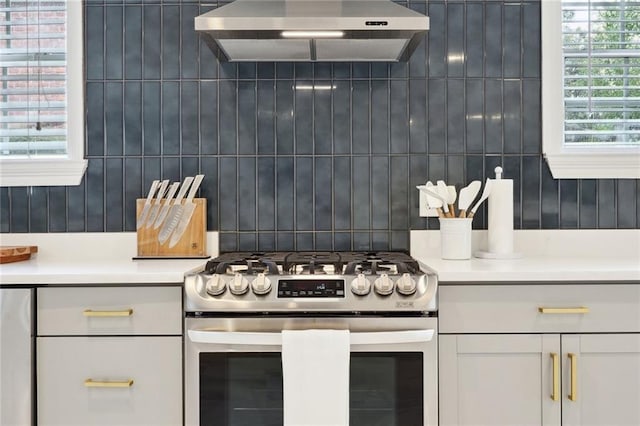 5537 Cherlyn Dr, New Orleans, LA 70124 - kitchen featuring stainless steel gas stove, range hood, light countertops, white cabinets, and decorative backsplash