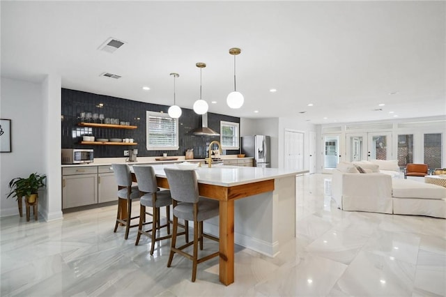5537 Cherlyn Dr, New Orleans, LA 70124 - kitchen with appliances with stainless steel finishes, wall chimney range hood, gray cabinets, light countertops, and light marble finish flooring