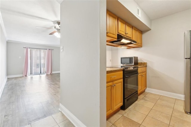 3805 Houma Blvd Unit A234, Metairie, LA 70006 - kitchen featuring black gas range, under cabinet range hood, stainless steel microwave, a ceiling fan, and baseboards