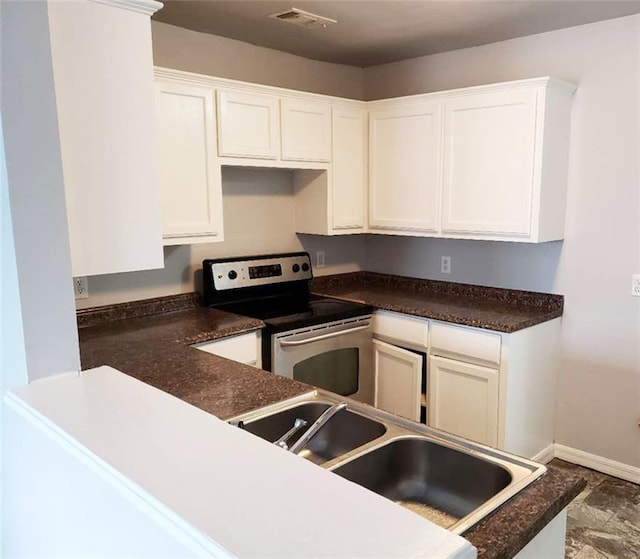 4020 N Claiborne Ave, New Orleans, LA 70117 - kitchen featuring electric range, a sink, white cabinets, and dark countertops