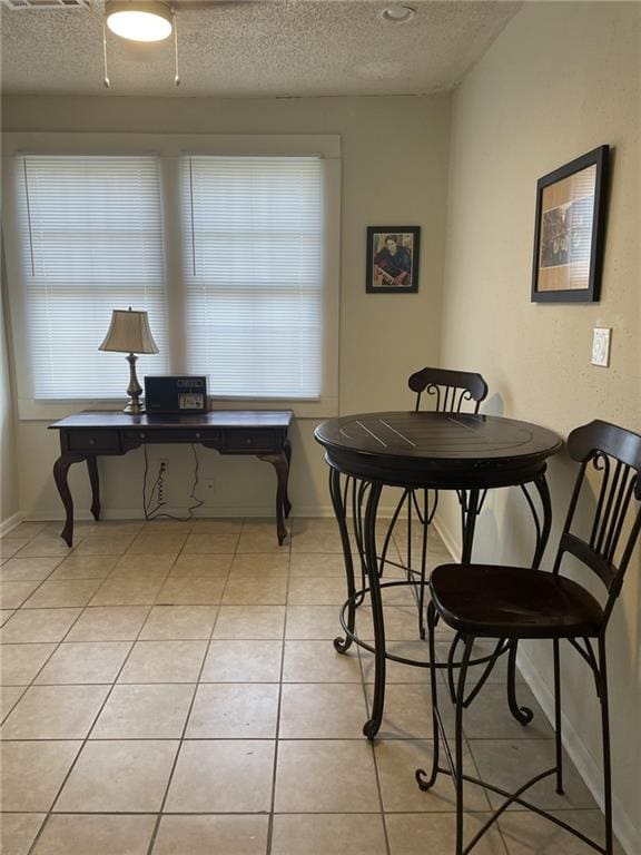 1740 Abundance St, New Orleans, LA 70119 - dining area featuring a textured ceiling, light tile patterned floors, and baseboards