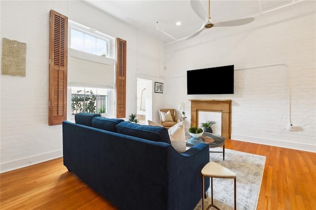 633 Tchoupitoulas St Unit 4, New Orleans, LA 70130 - living room with baseboards, a ceiling fan, a high ceiling, wood finished floors, and a fireplace