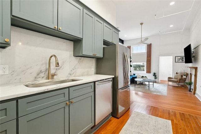 633 Tchoupitoulas St Unit 4, New Orleans, LA 70130 - kitchen with stainless steel dishwasher, a sink, light countertops, light wood finished floors, and decorative backsplash