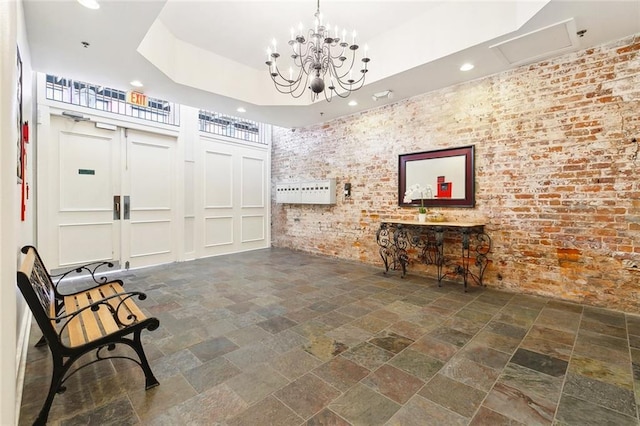 633 Tchoupitoulas St Unit 4, New Orleans, LA 70130 - living area with stone tile flooring, recessed lighting, brick wall, and a chandelier