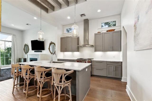 1113 9th St, New Orleans, LA 70115 - kitchen with wall chimney exhaust hood, gray cabinets, a sink, wood finished floors, and recessed lighting