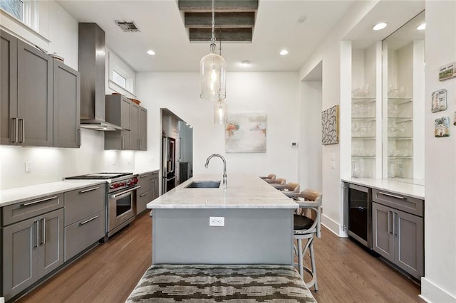 1113 9th St, New Orleans, LA 70115 - kitchen with appliances with stainless steel finishes, a sink, wine cooler, wall chimney exhaust hood, and dark wood-style flooring