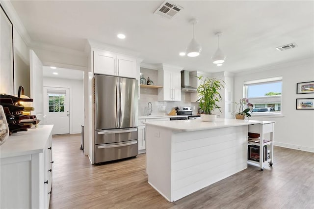917 Belmont Pl, Metairie, LA 70001 - kitchen with appliances with stainless steel finishes, wall chimney exhaust hood, crown molding, light countertops, and plenty of natural light